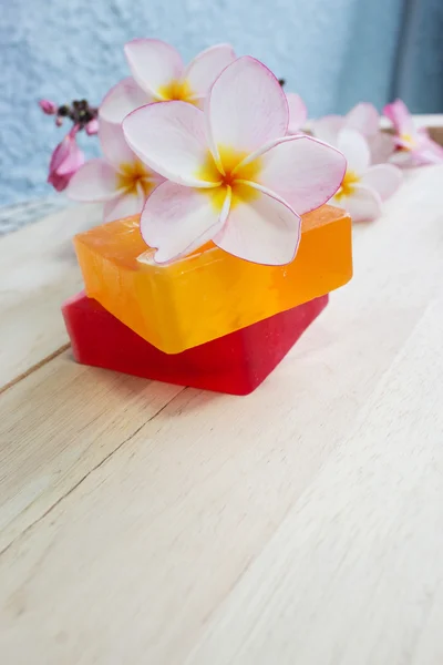 Soap and frangipani flower on wooden floor massage and spa concept background
