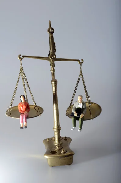 Man and woman sitting on golden weighing scale