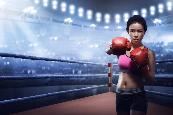 Attractive asian female boxer in boxing arena