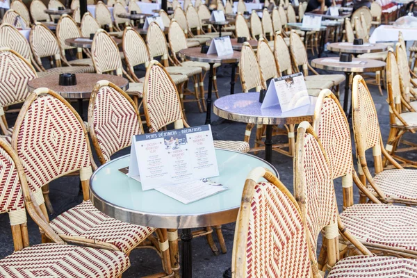 PARIS, FRANCE, on JULY 9, 2016. Little tables of typical Parisian cafe on the sidewalk expect visitors in the morning