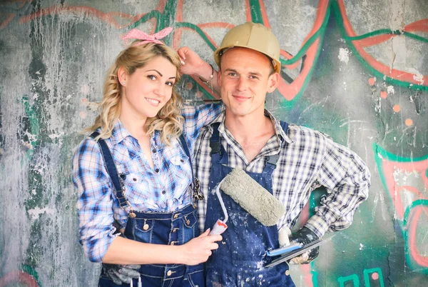 Young couple in overalls with tools. Concept of construction and home repair.