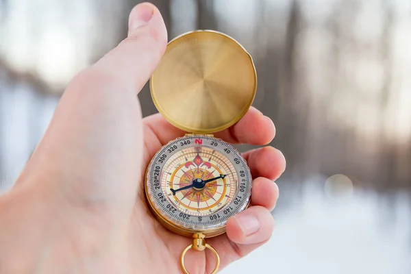 Concept - orienteering in the woods, a route. Winter, man holds compass in hand
