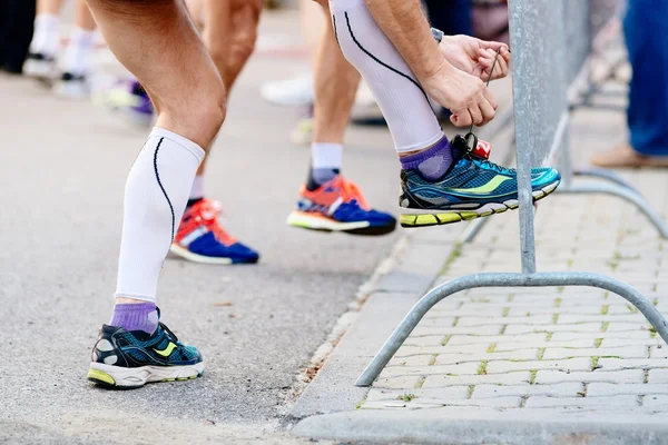 Man ties his sport running shoe before the race.