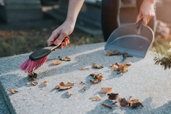 A woman cleans the grave