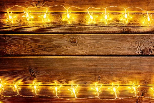 Christmas lights on wooden rustic background.