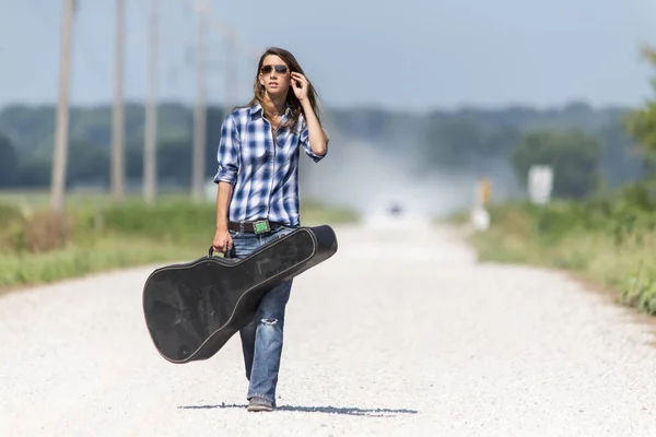 A Female Hitchhikes On A Dirt Road