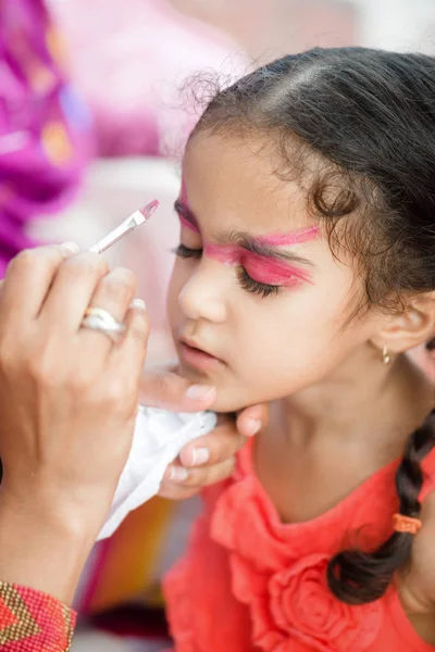 Four year old cute pretty girl child young with her face painted for fun at a birthday party