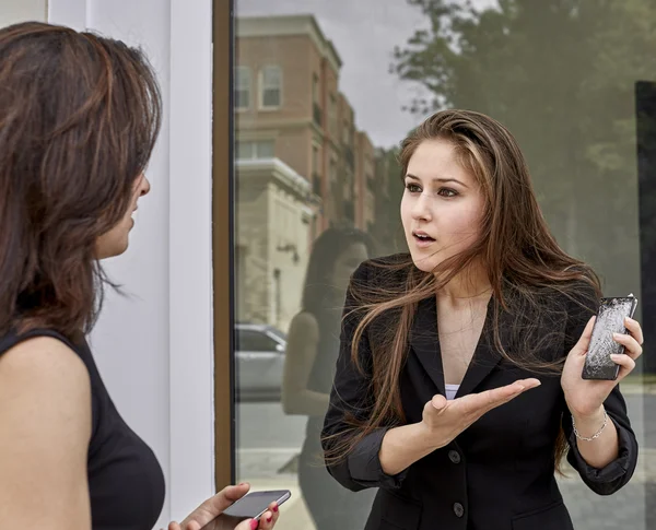 Two Young Women arguing over a Broken Cell Phone