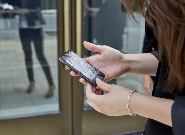 Woman holding a Broken Cell Phone