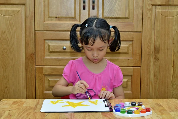 A cute young asian girl painting a picture