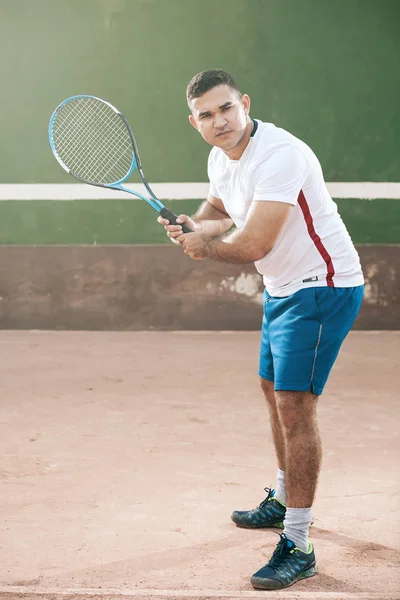 Handsome young man on tennis court. Man playing tennis.