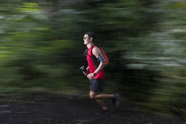 Asian man running on forest trail