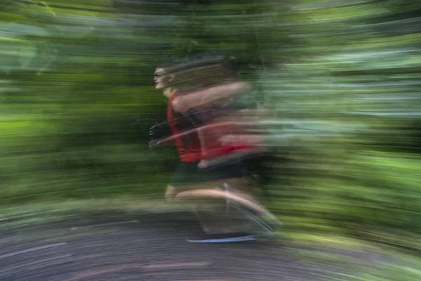 Asian man running on forest trail