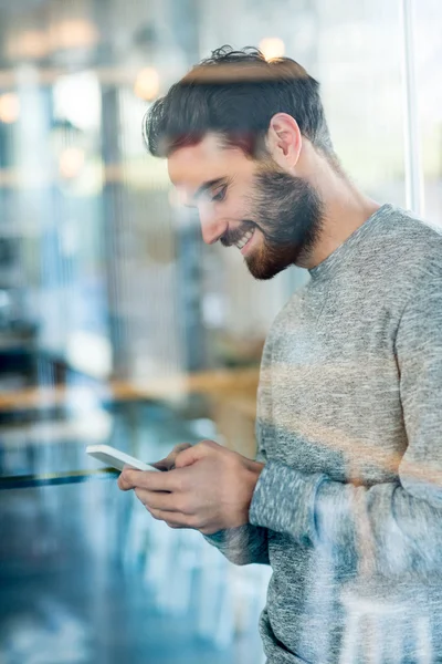 Smiling man using mobile phone