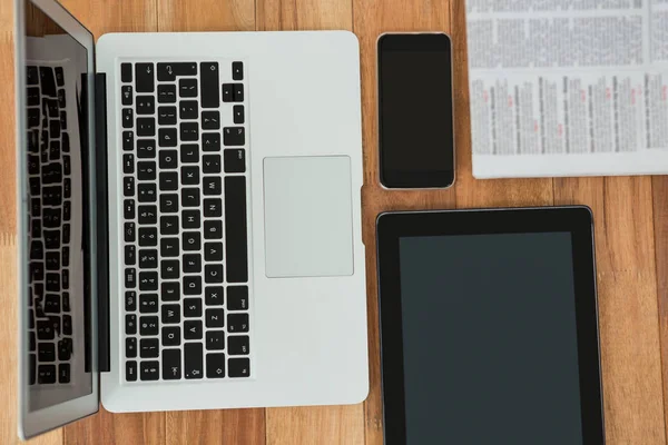 Laptop, digital tablet, phone, and newspaper