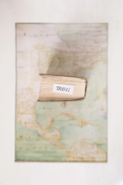 Travel idea. Text, book and an old blurred map.