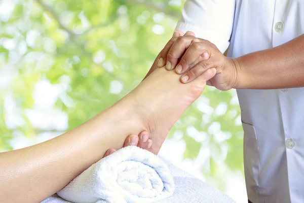 Masseur doing reflexology,Thai foot massage in spa on nature bac