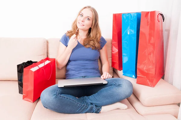 Woman sitting on couch thinking of making an online order