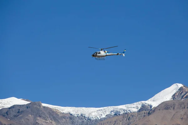 Mountain rescue helicopter in Himalaya Mountains on background blue sky. Nepal