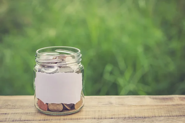 Money in the jar on wooden table