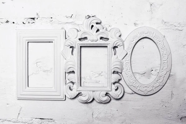 Three white plaster frames for pictures on the wall