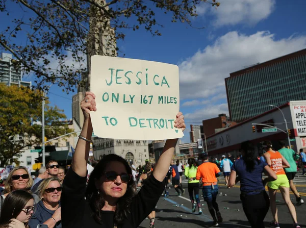 Spectator supports New York City Marathon runners with sign.