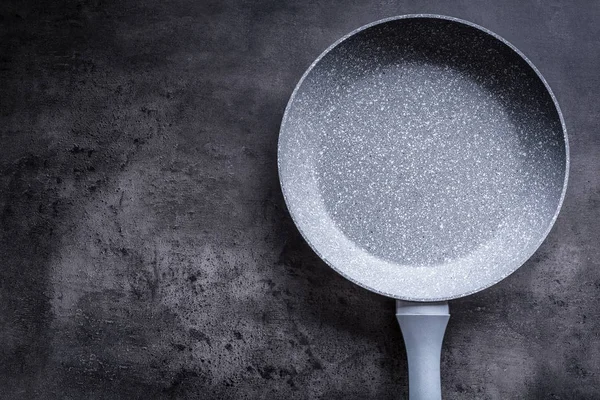 Ceramic pan on concrete kitchen board. Kitchen utensil. Empty pan