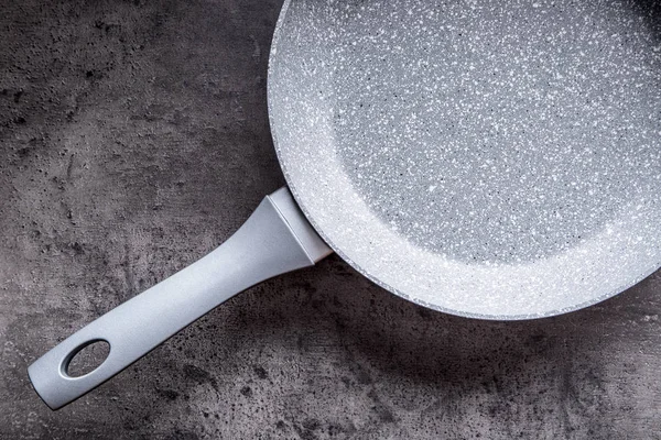 Ceramic pan on concrete kitchen board. Kitchen utensil. Empty pan