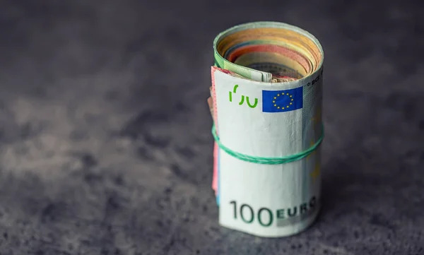 Euro banknotes. Euro currency. Euro money. Close-up Of A Rolled Euro Banknotes On concrete or Wooden table