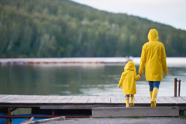 Woman and child in yellow raincoats