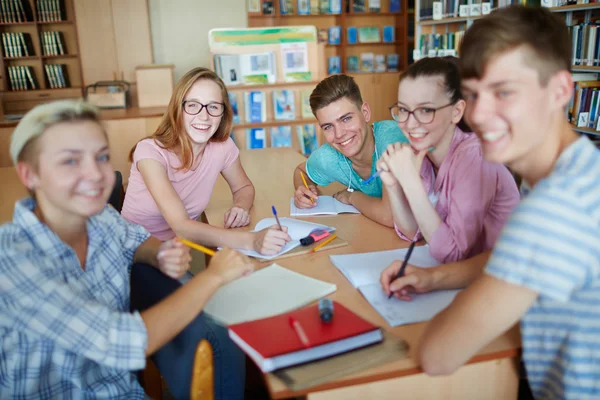 Successful teens sitting in college library