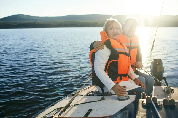 Senior people in life-vests sitting on yacht