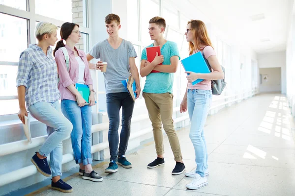 Teenagers discussing schoolwork during break