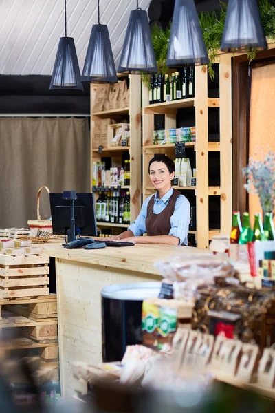 Small business owner standing by cashdesk