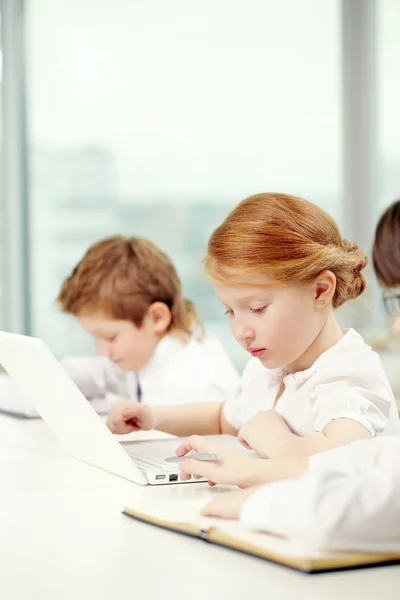 Little girl working with computer in classroom