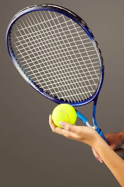 Tennis racket and ball in female hand