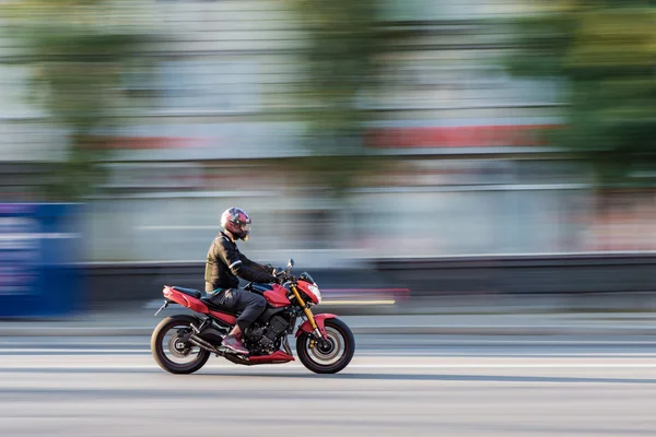 Fast moving biker on motorcycle with blur background