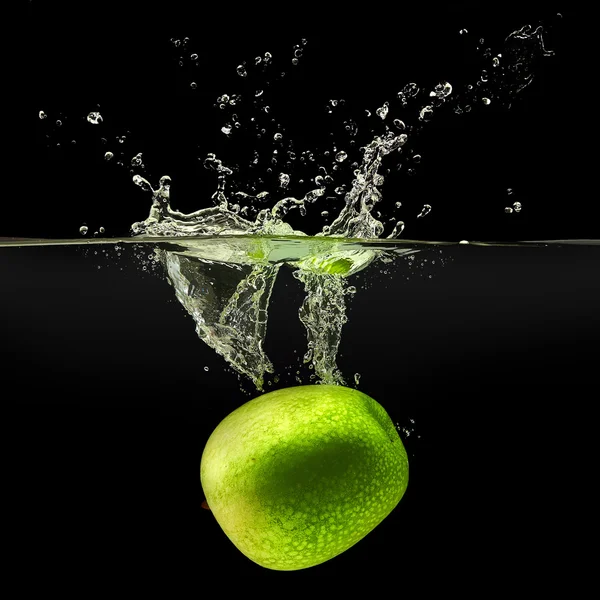 Green apple falling in water on black background