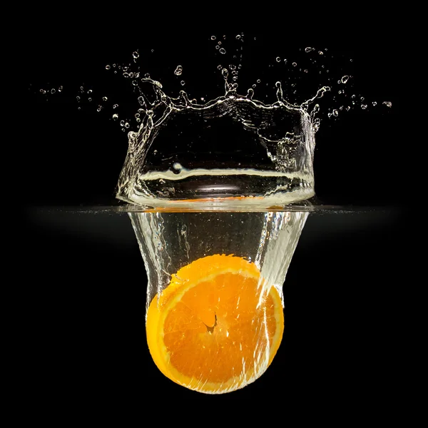 Fresh fruits falling in water with splash on black