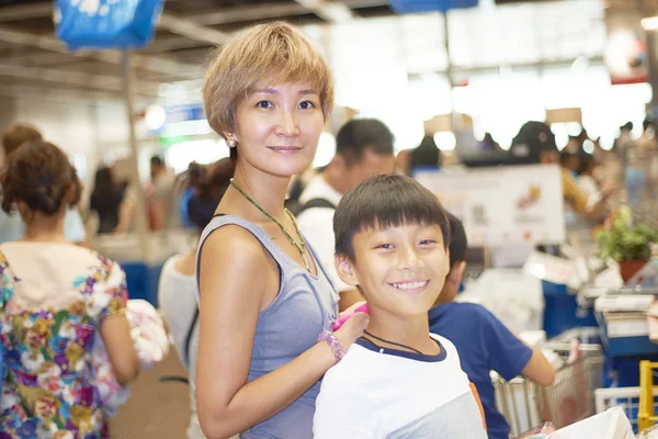 Mother and son waiting for checkout in shopping mall