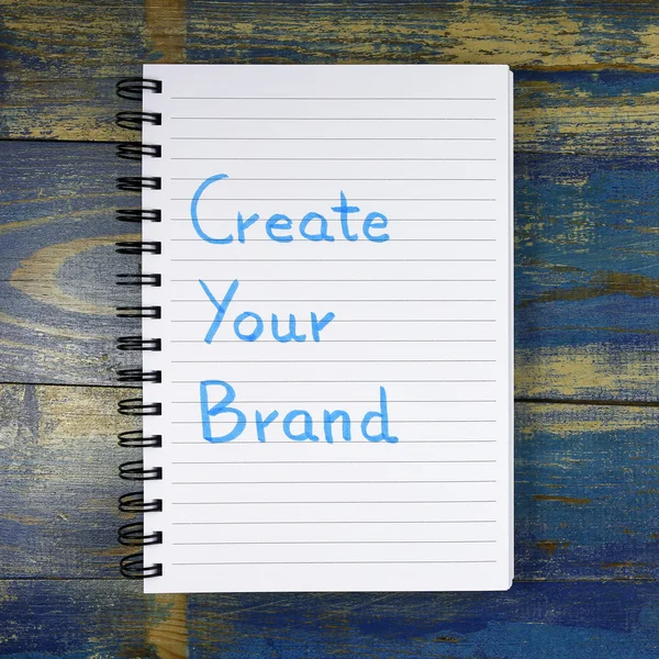 Create Your Brand text written in notebook on wooden background