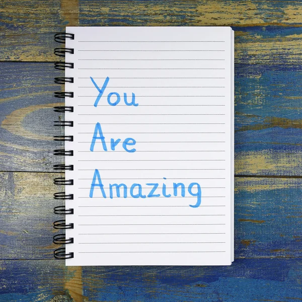 You Are Amazing text written in notebook on wooden background