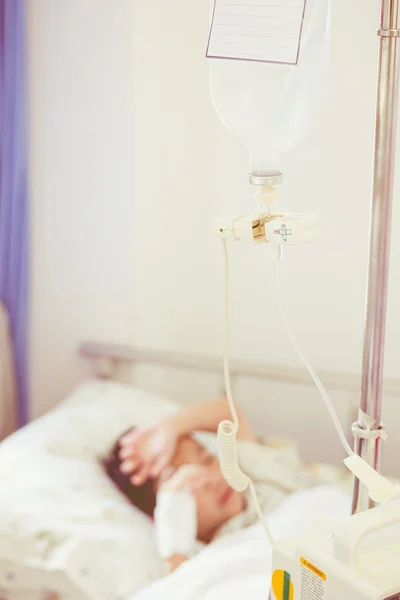 Illness asian boy lying on sickbed in hospital. Vintage style.