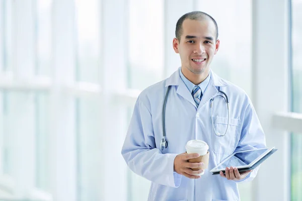 Doctor with tablet and coffee