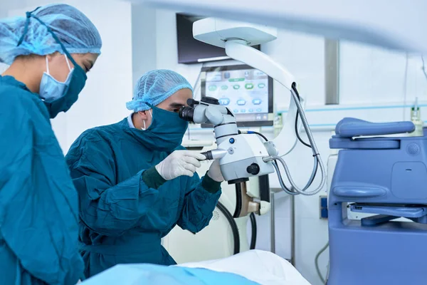 Professional ophthalmologists performing operation