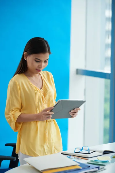 Female entrepreneur reading something on tablet