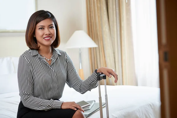 Business lady with suitcase sitting in hotel room
