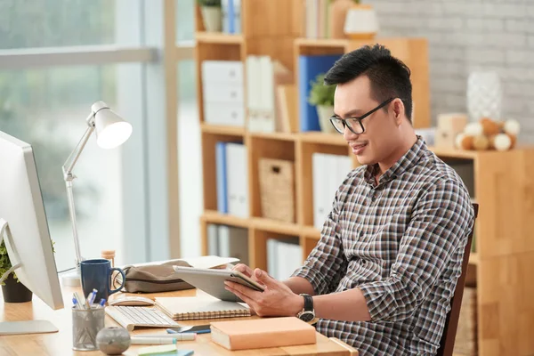 Man in glasses using application on tablet