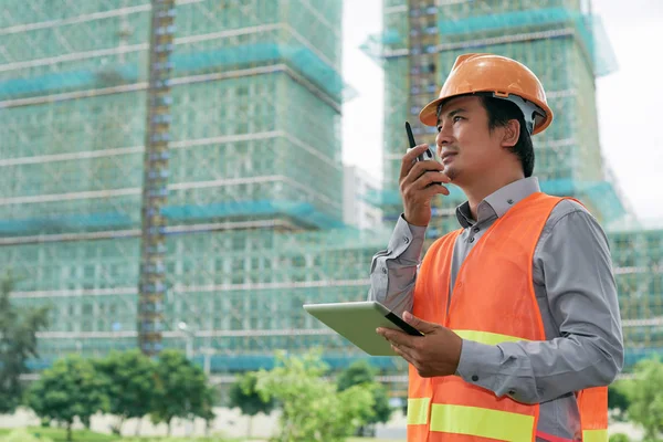 Contractor using walkie-talkie