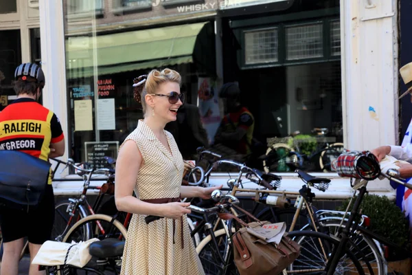 Unidentified woman in vintage style clothes with bicycle on Tweed Ride, Amsterdam
